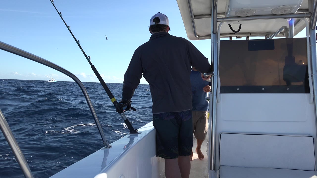 Men on a small fishing boat with rods and open ocean