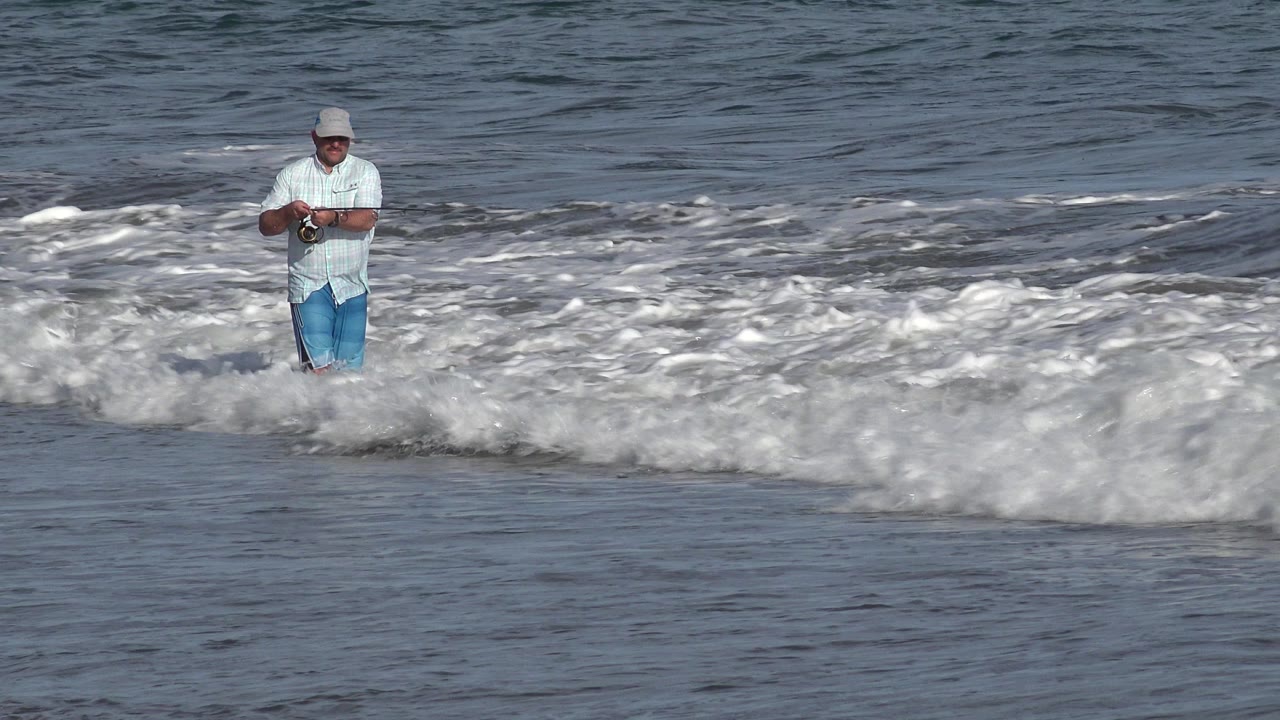 Adult man fishing in breaking surf