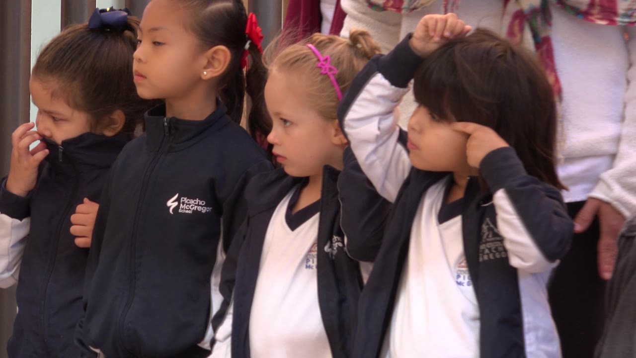 The four girls remain grouped in San Jose Del Cabo, with the left girl holding fabric near her face, the center girls looking sideways, and the right girl lifting her hands over her head.