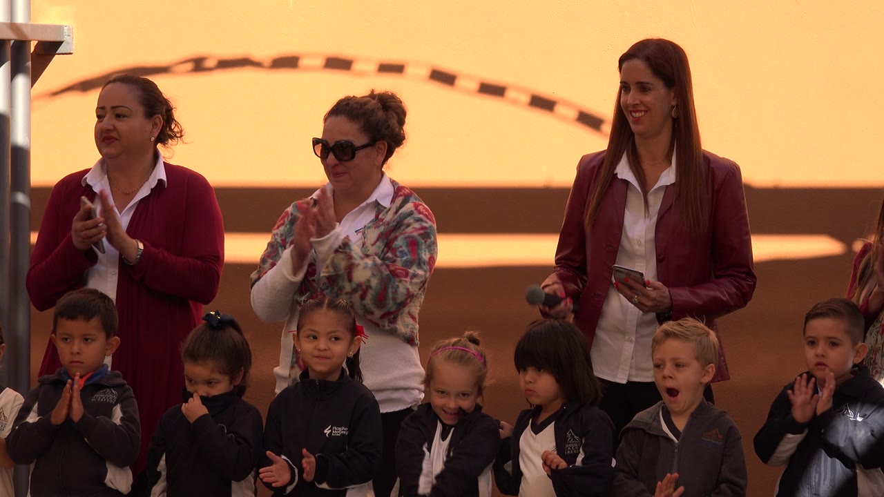 Children watching as adult women applaud behind them