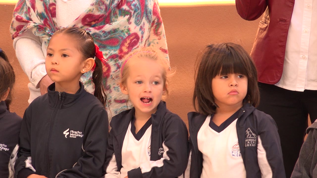 Blond-haired girl opens her mouth while other girls stand nearby.