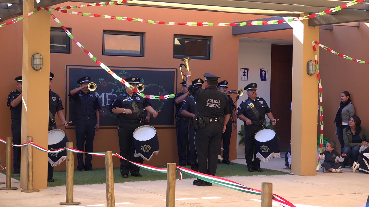 Uniformed police band performing under red, white, and green streamers.