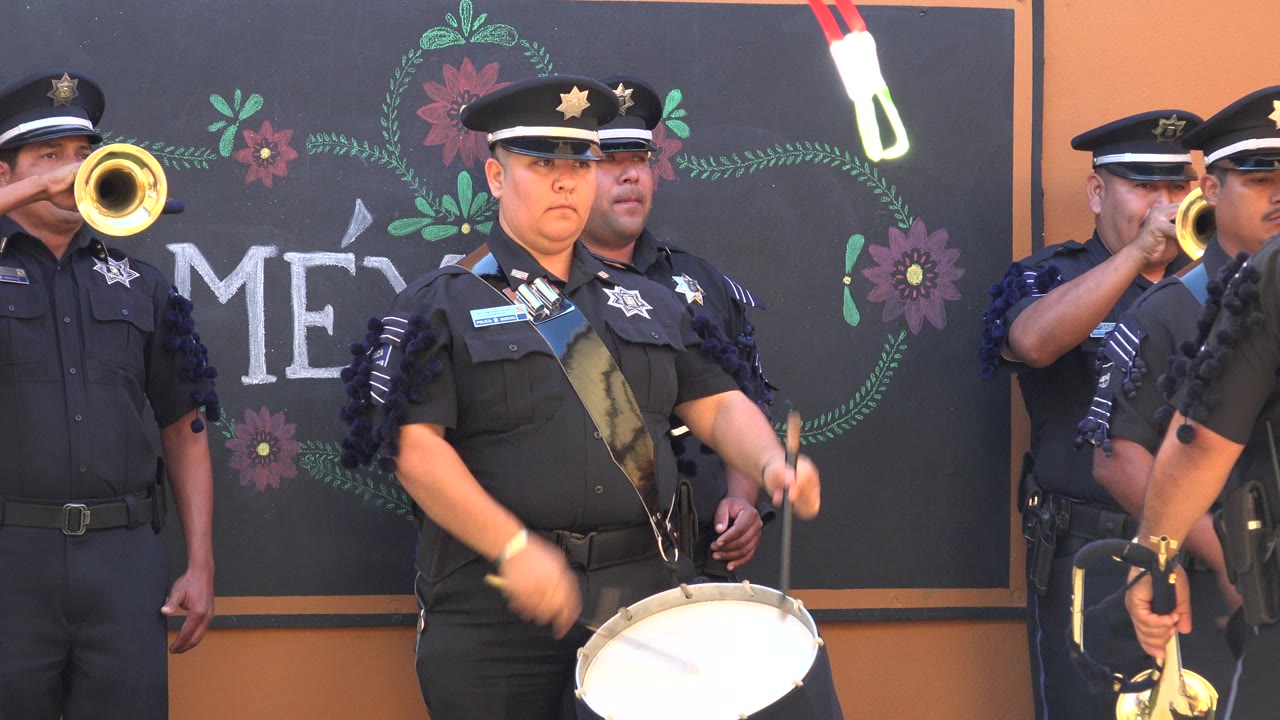 In San Jose del Cabo, Mexico, the snare drummer faces forward while a brass player at left plays and another musician is partly visible at the right edge.