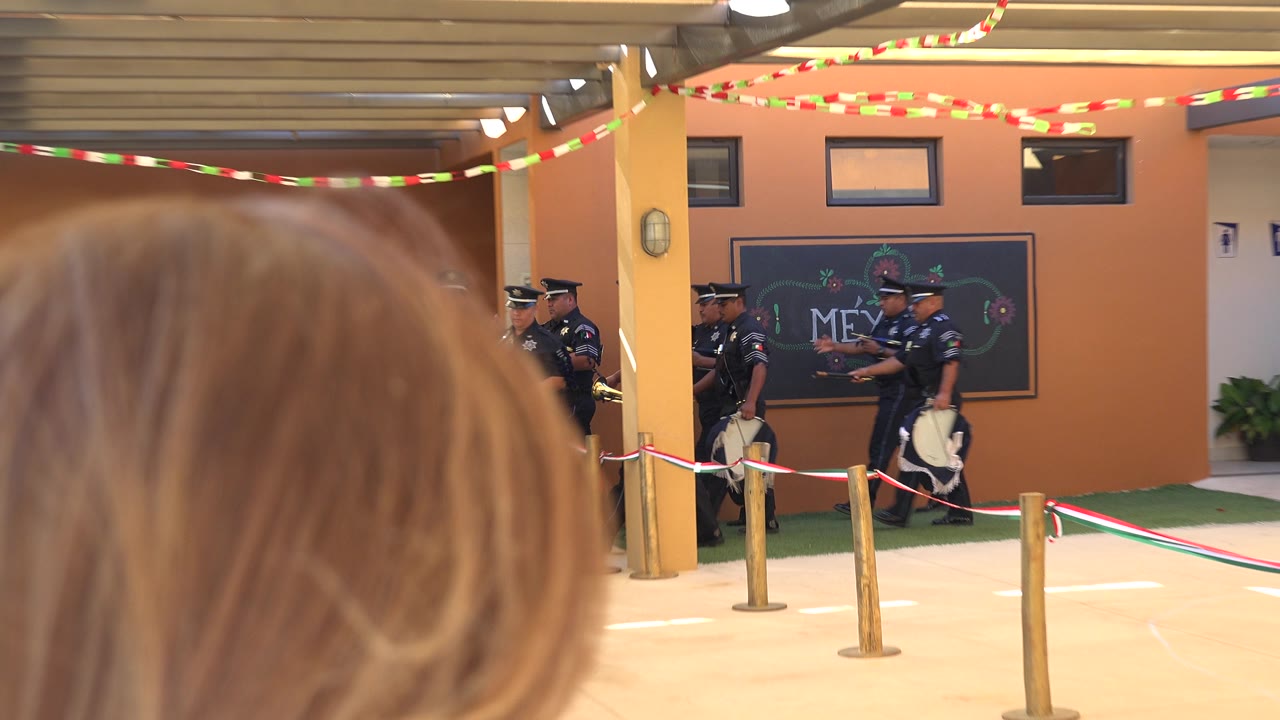 Spectator head in foreground with police procession farther back under bunting.
