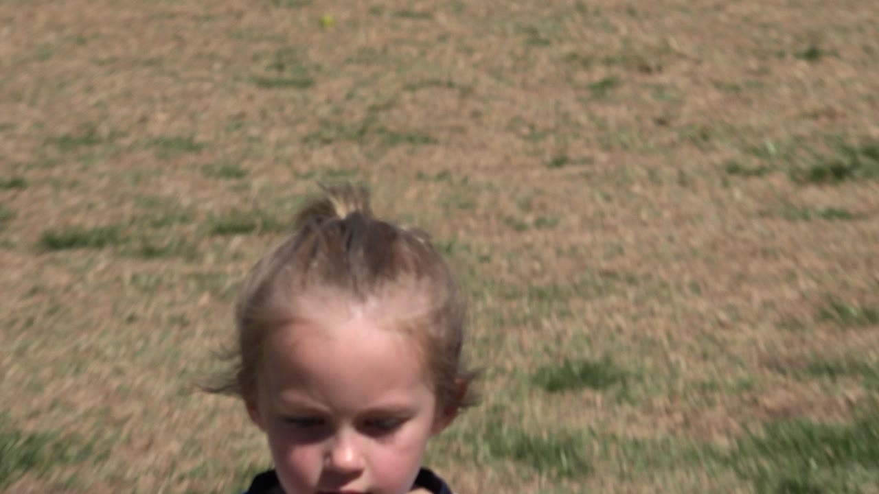 Close view of a young girl on a grass soccer field.