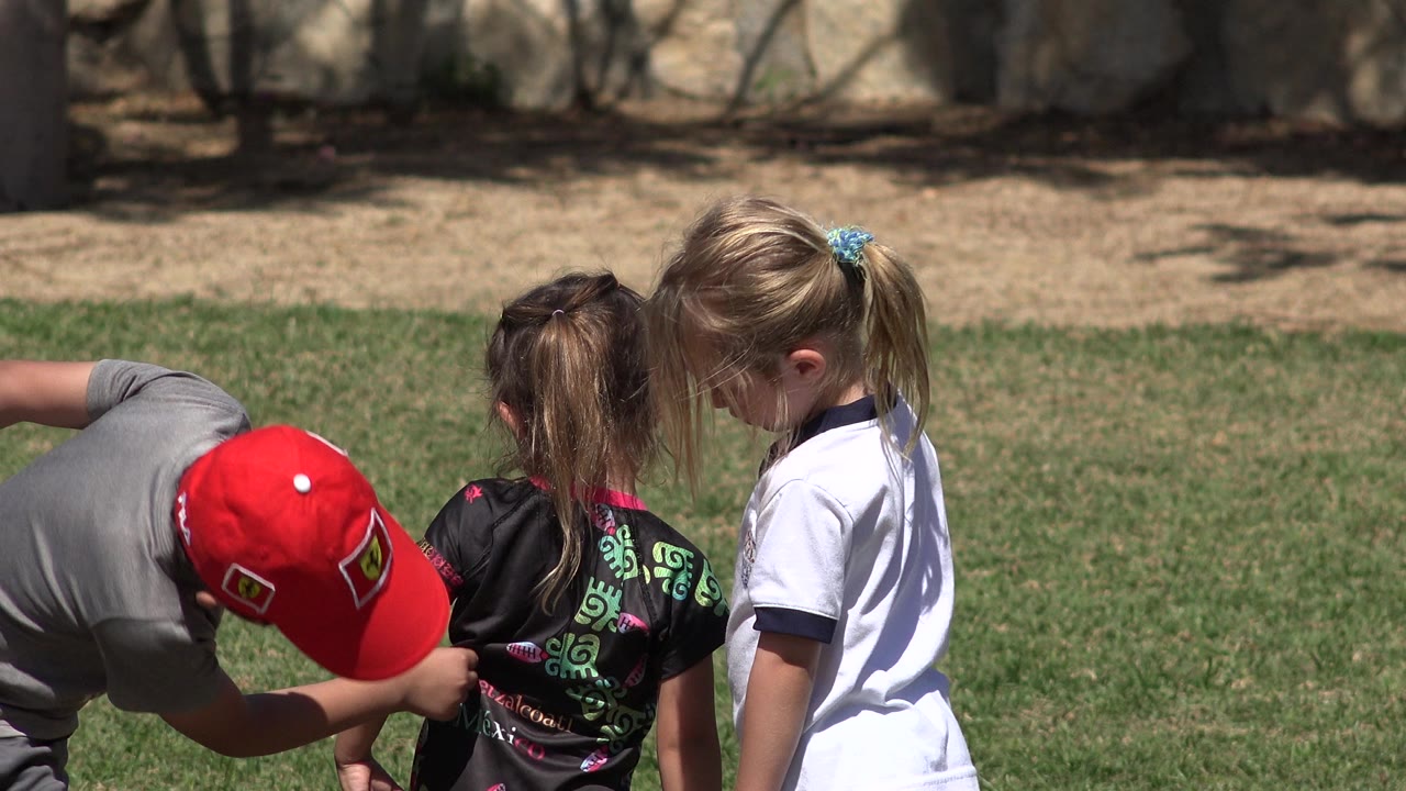 Children gathered on a sunny grass field.