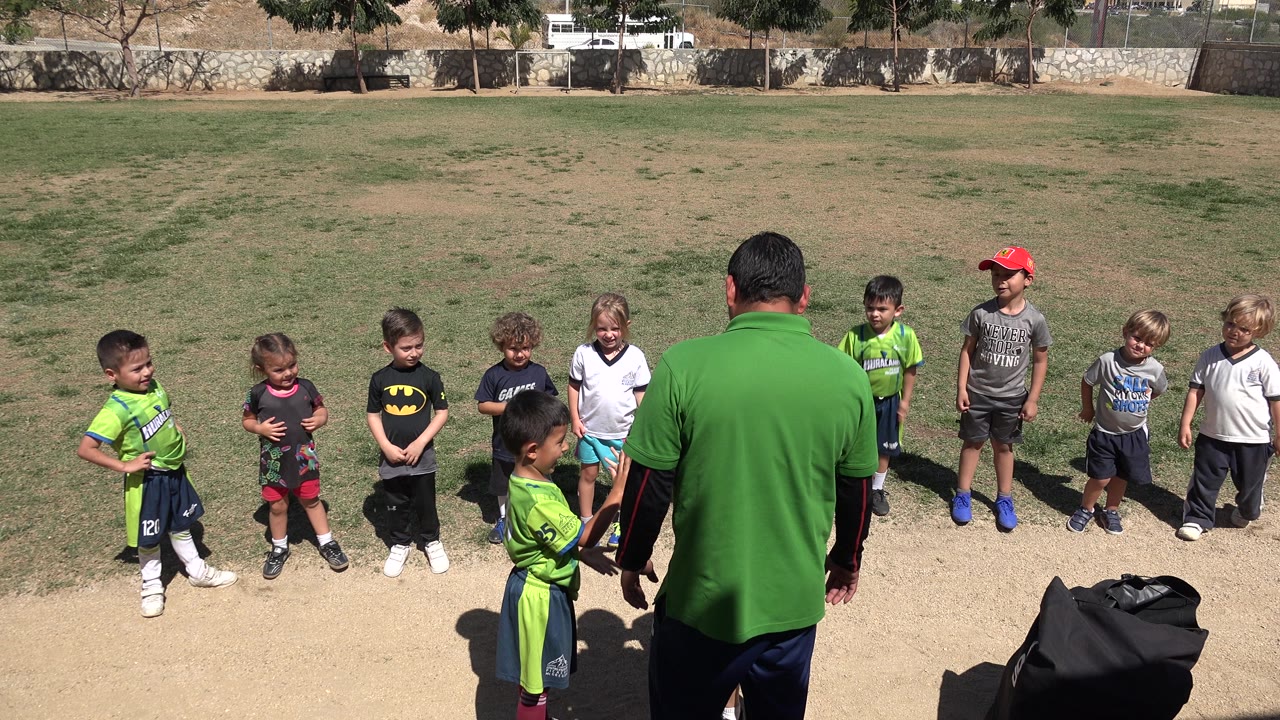 Coach and children gathered during youth soccer practice.