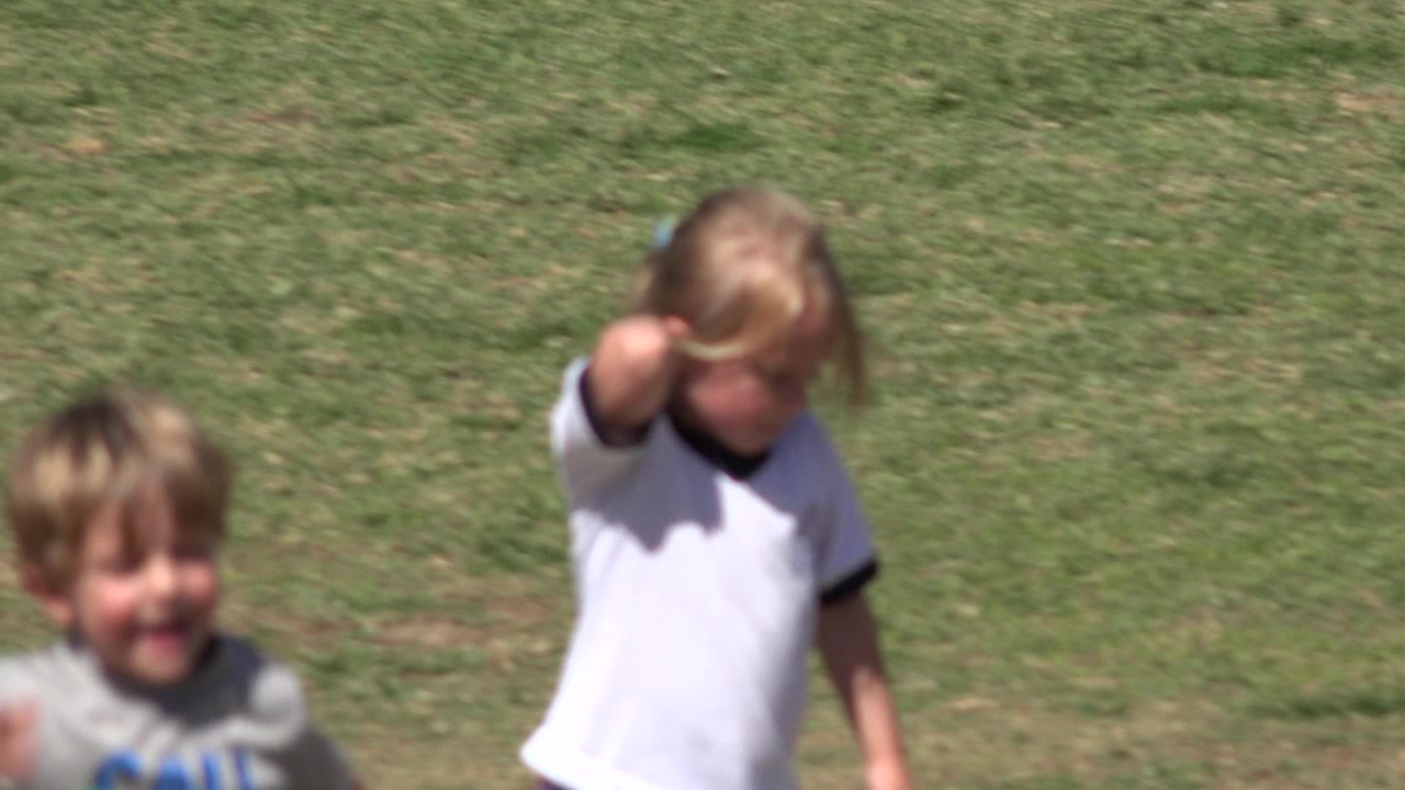 Blurry children running on a grass field