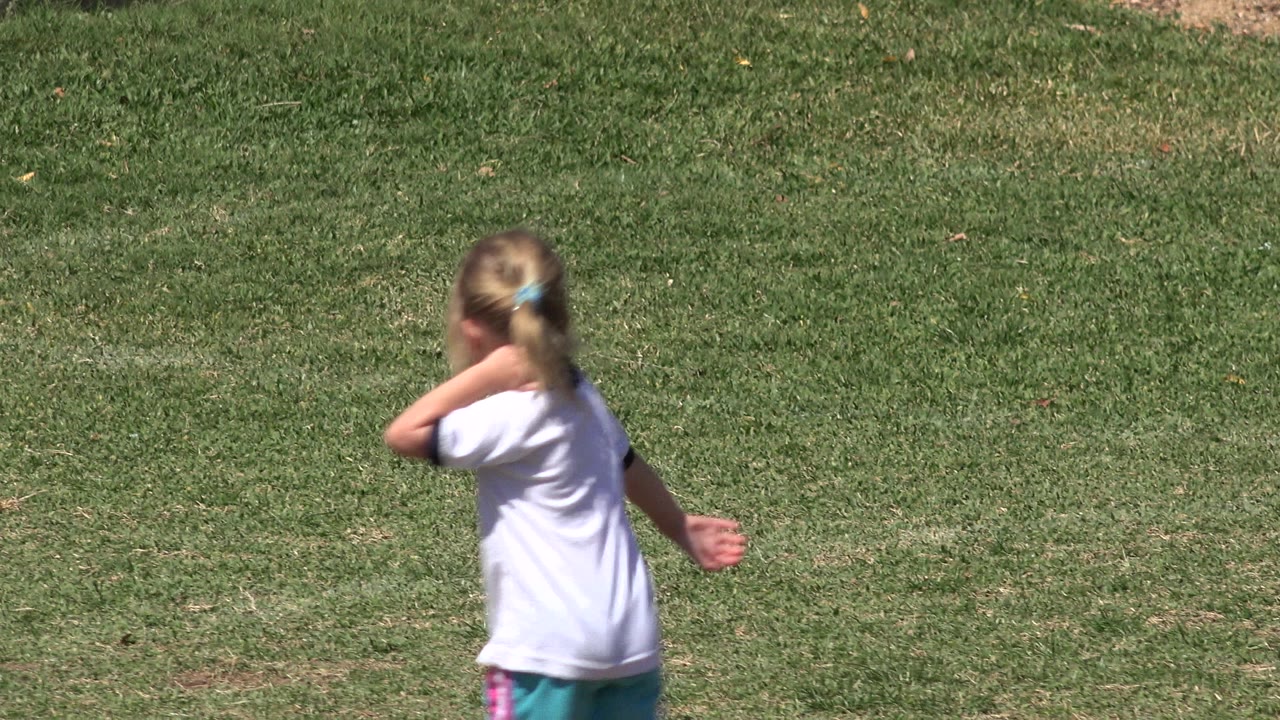 The same child continues across the sunlit grass in San Jose del Cabo, Mexico, with the field filling the background.