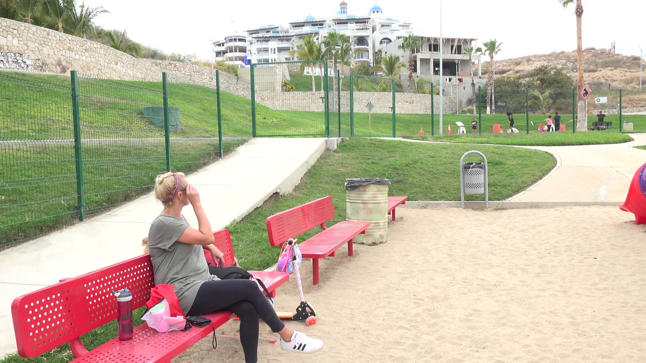 Woman on a red bench looking back in a park.
