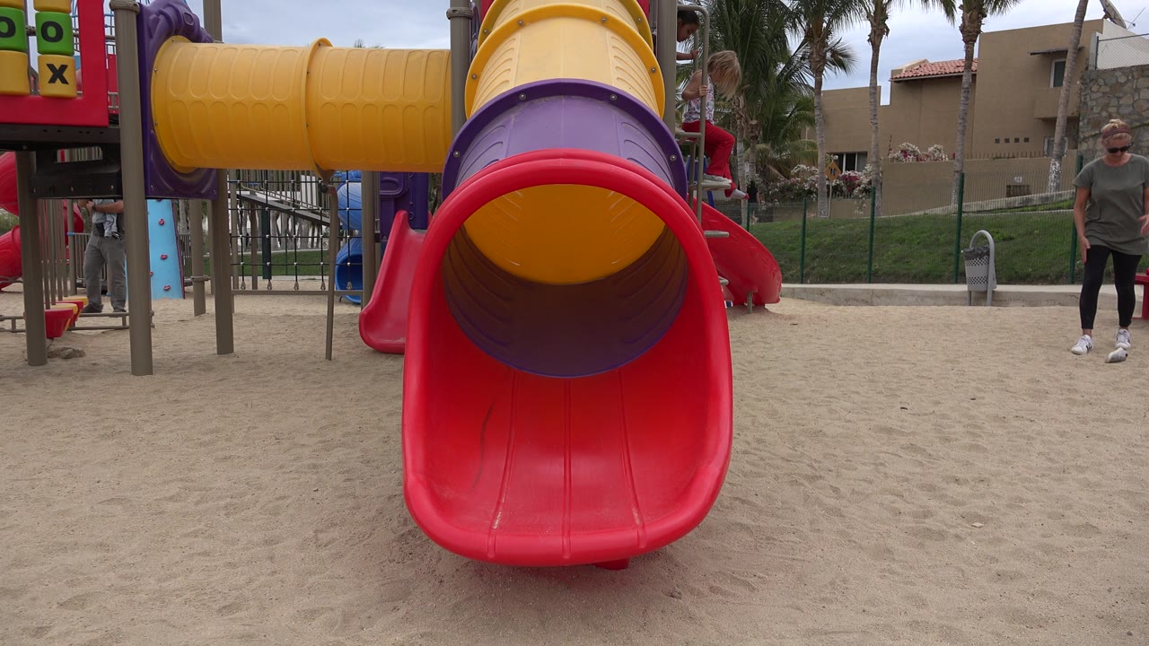 Playground slide with adult woman near the right side.