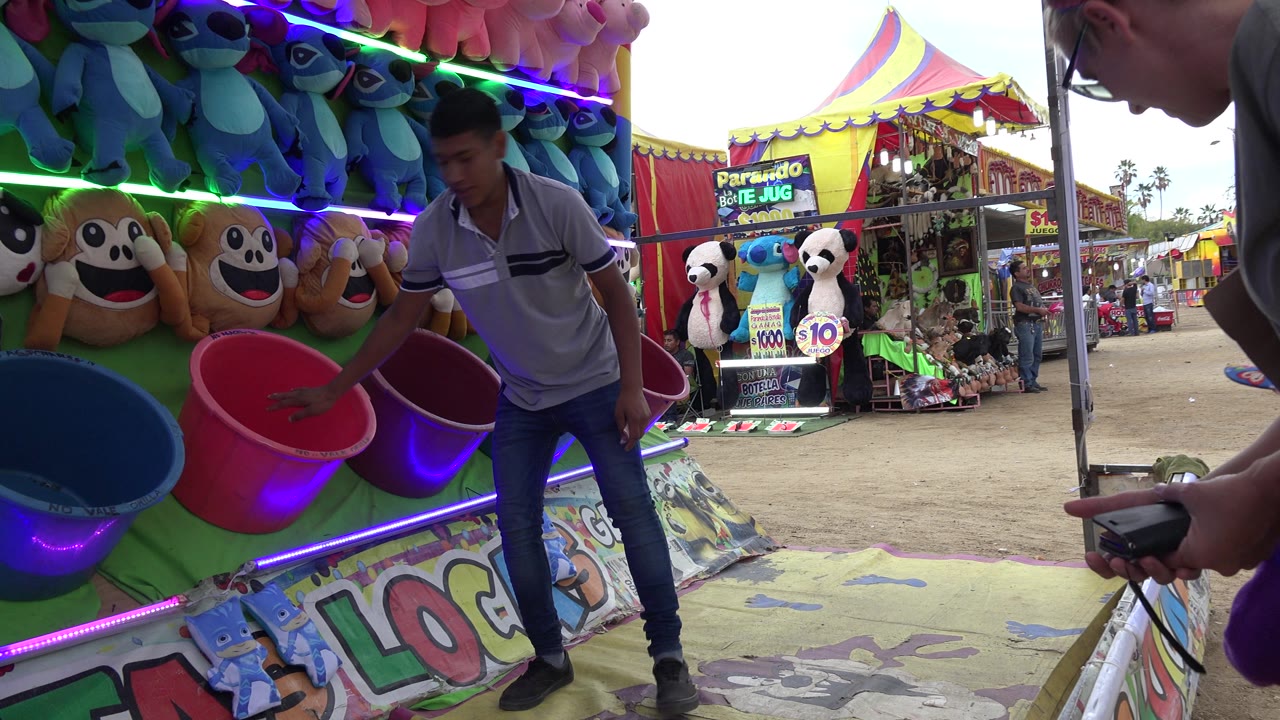 Adult stands beside colorful buckets while the child is near the booth edge.