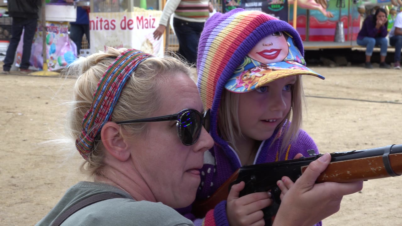 Girl and woman look toward the toy rifle pointed right.