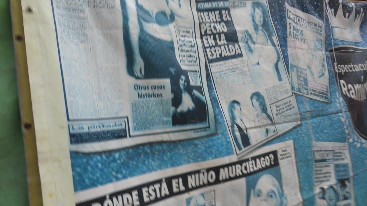 Another close view in San Jose Del Cabo shows layered Spanish newspaper graphics across a blue surface, with partial headlines and no visible people.