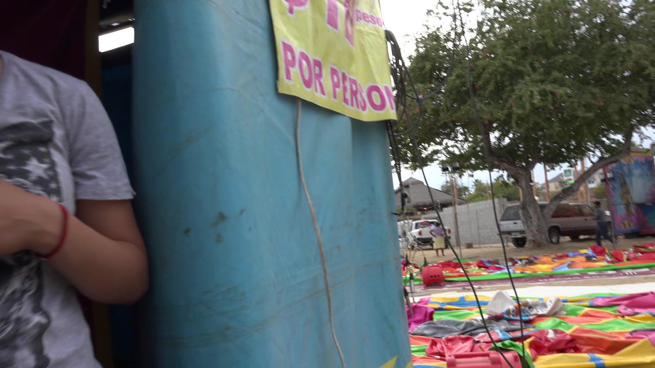 Partial person standing by a blue inflatable entrance.