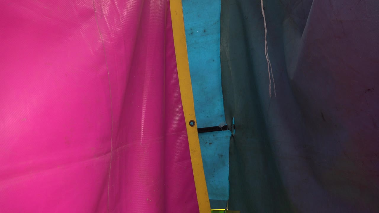 Pink, yellow, blue, teal, and purple tent fabric panels at close range.