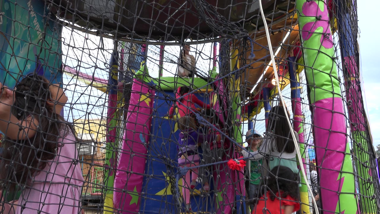 A girl in a pink top stands near the net while other children move inside the bright inflatable play structure in San Jose Del Cabo, Mexico.