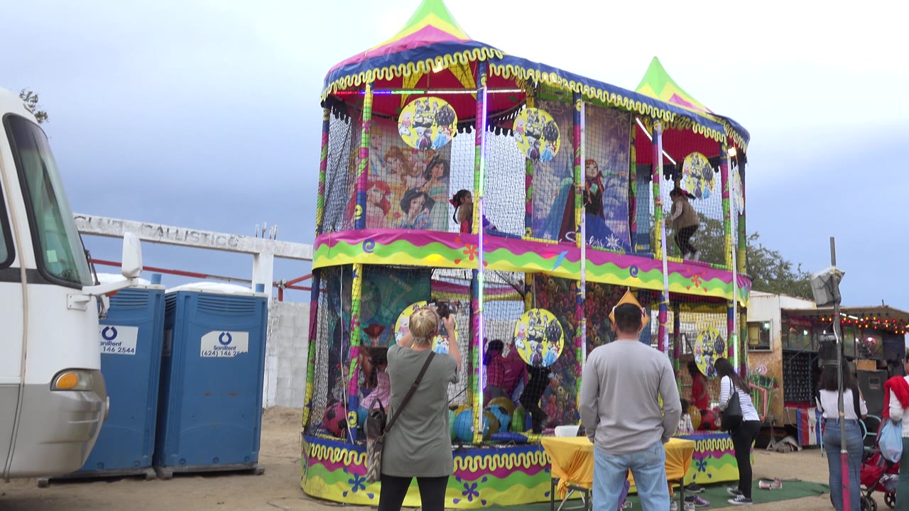 Colorful two-story play attraction with children inside and adults nearby.