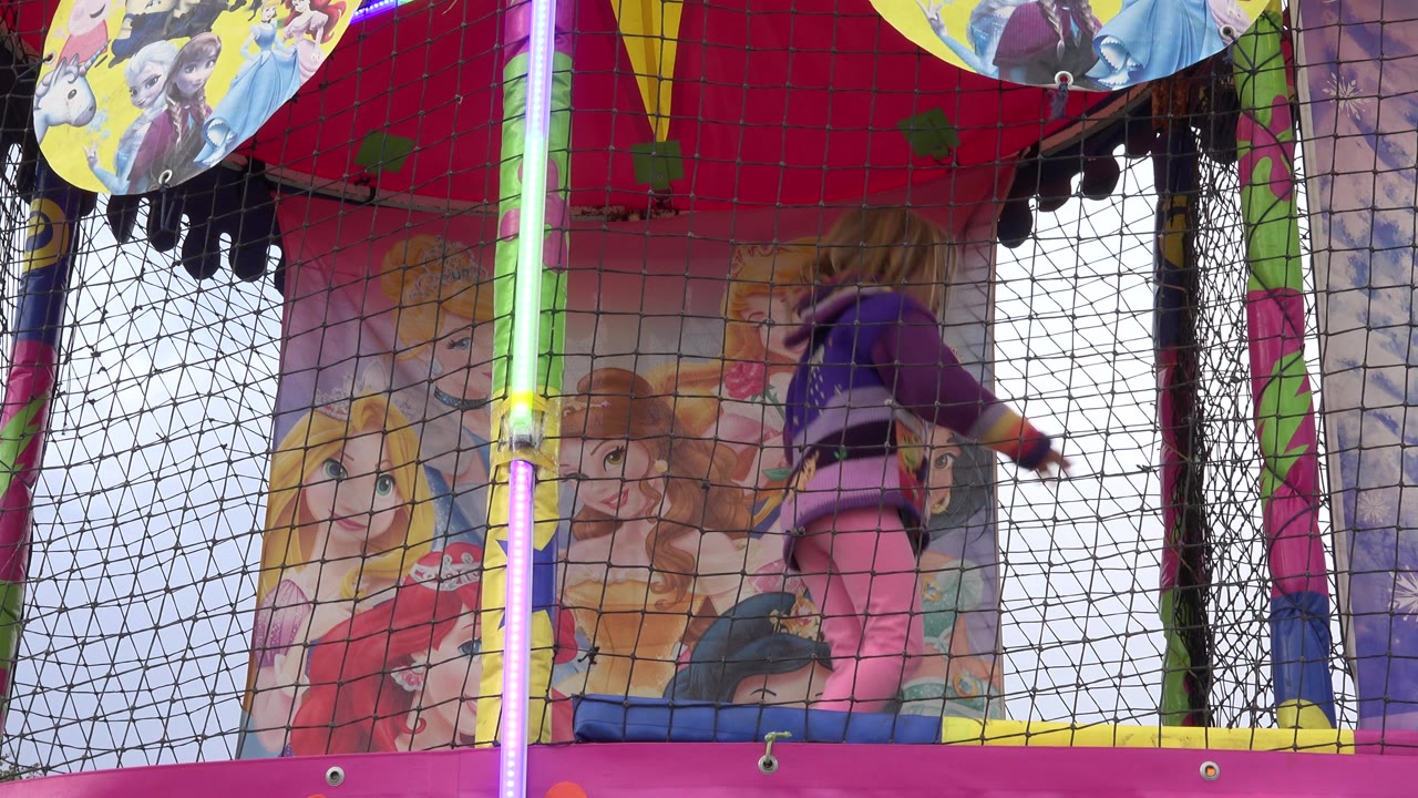 Child jumping upward near the right side of the trampoline.