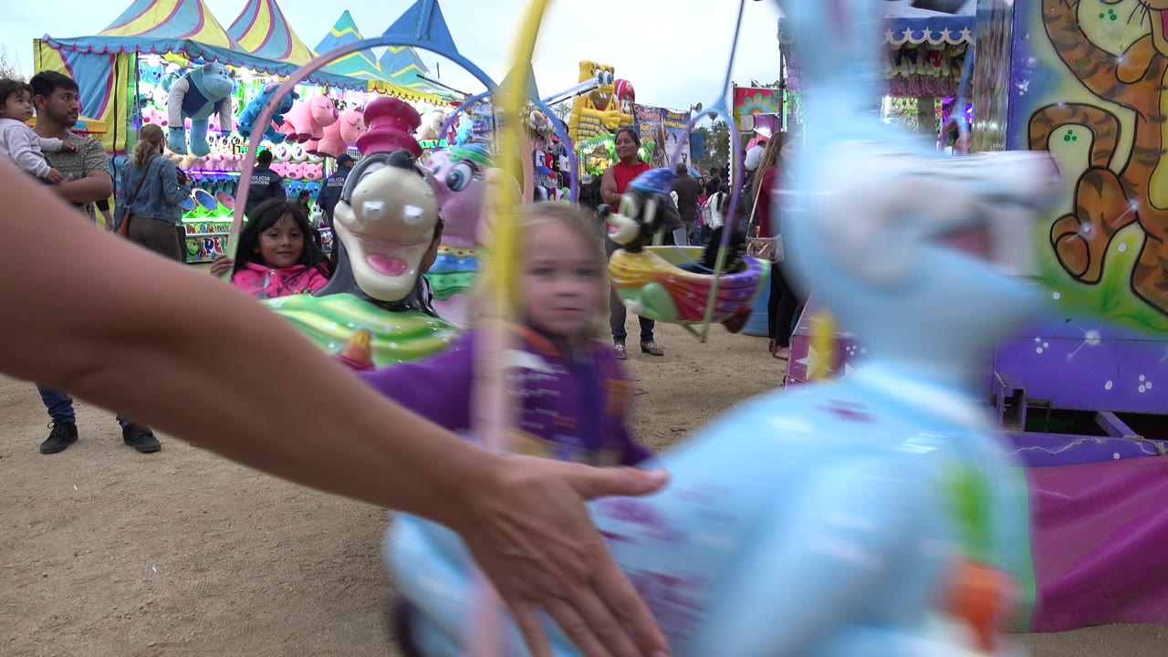 Children on colorful swing ride with adults nearby