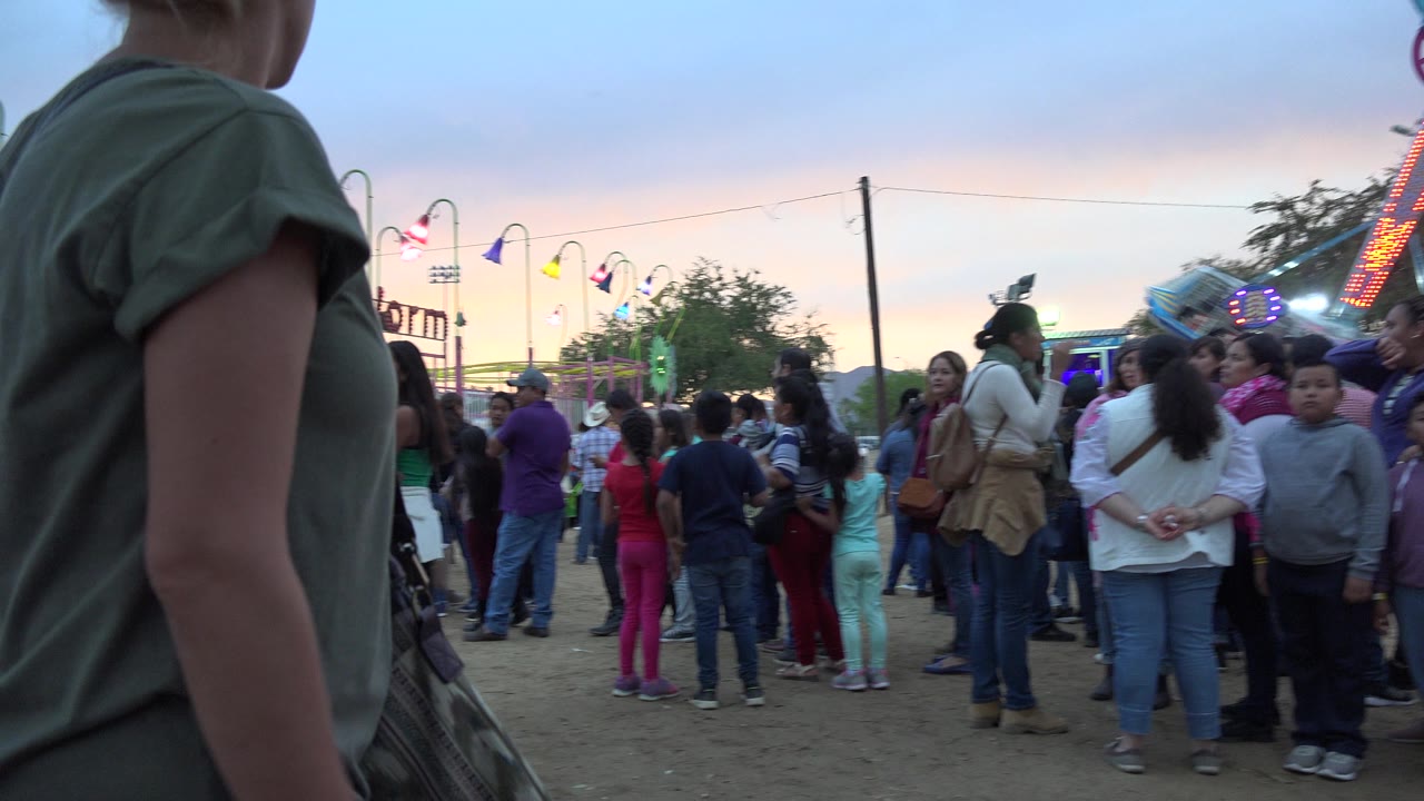 Woman passing close to camera at a crowded amusement park