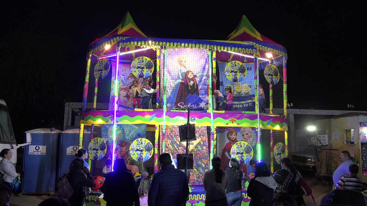 Night carnival jumping pavilion with families in front