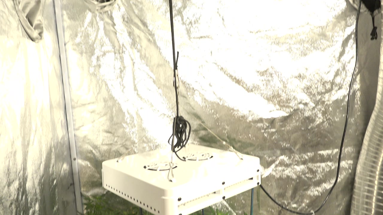 White rectangular equipment hangs by a wire inside a reflective silver enclosure in Westminster, Colorado, with black cords and no visible people.