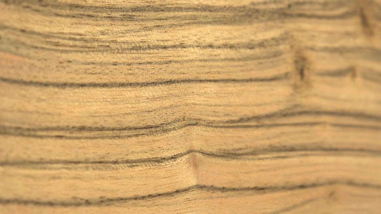 Close varnished wood surface shows horizontal brown grain lines and warm highlights in Westminster, Colorado, with no visible people.