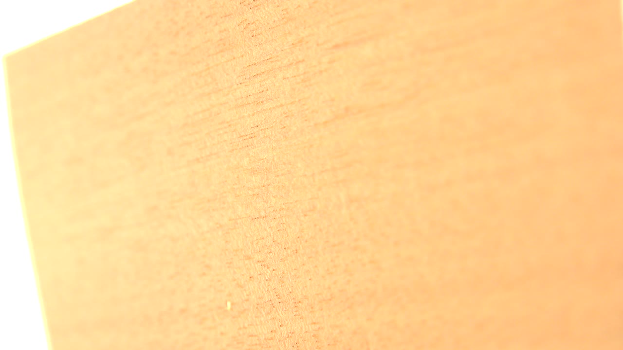 A close Westminster, Colorado frame shows a yellow tan wood board filling most of the view, with bright overexposed background at the top and no visible people.