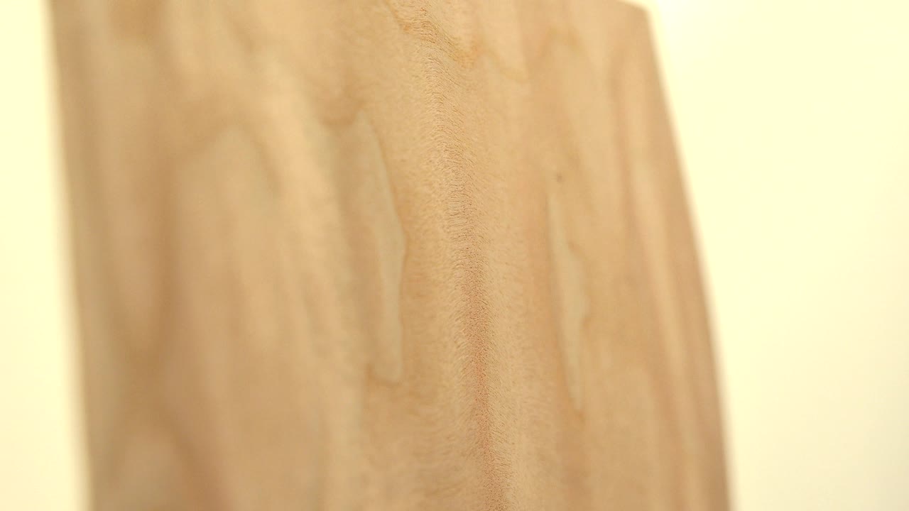 Close side view of the yellow wood board in Westminster, Colorado, with more of the grain face visible and a blown-out light area at left, no visible people.