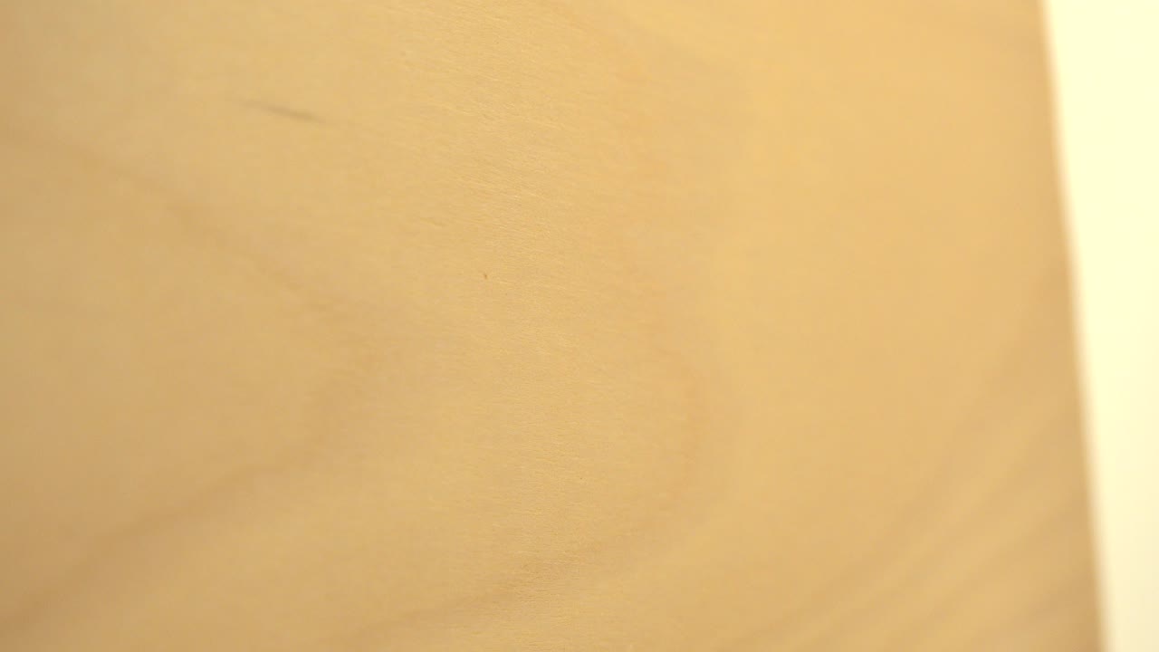 Warm yellow wood surface with a pale vertical edge at right.