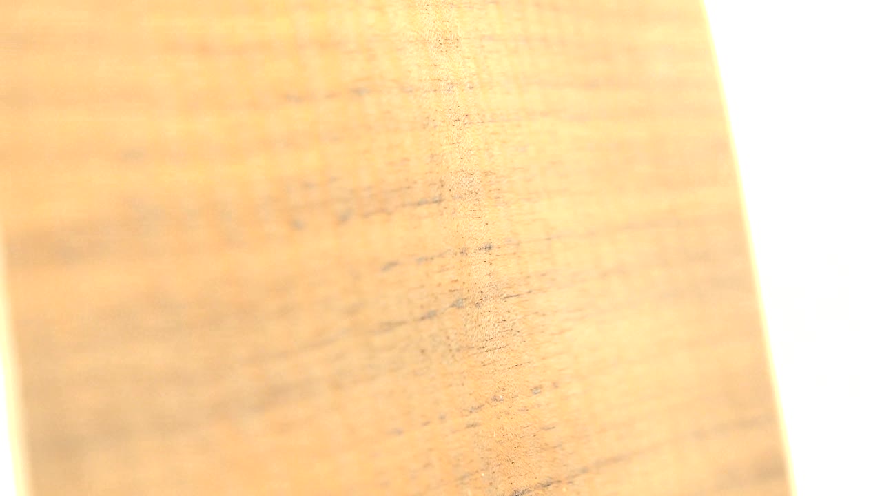 Warm brown wood-like surface with grain and a bright edge.