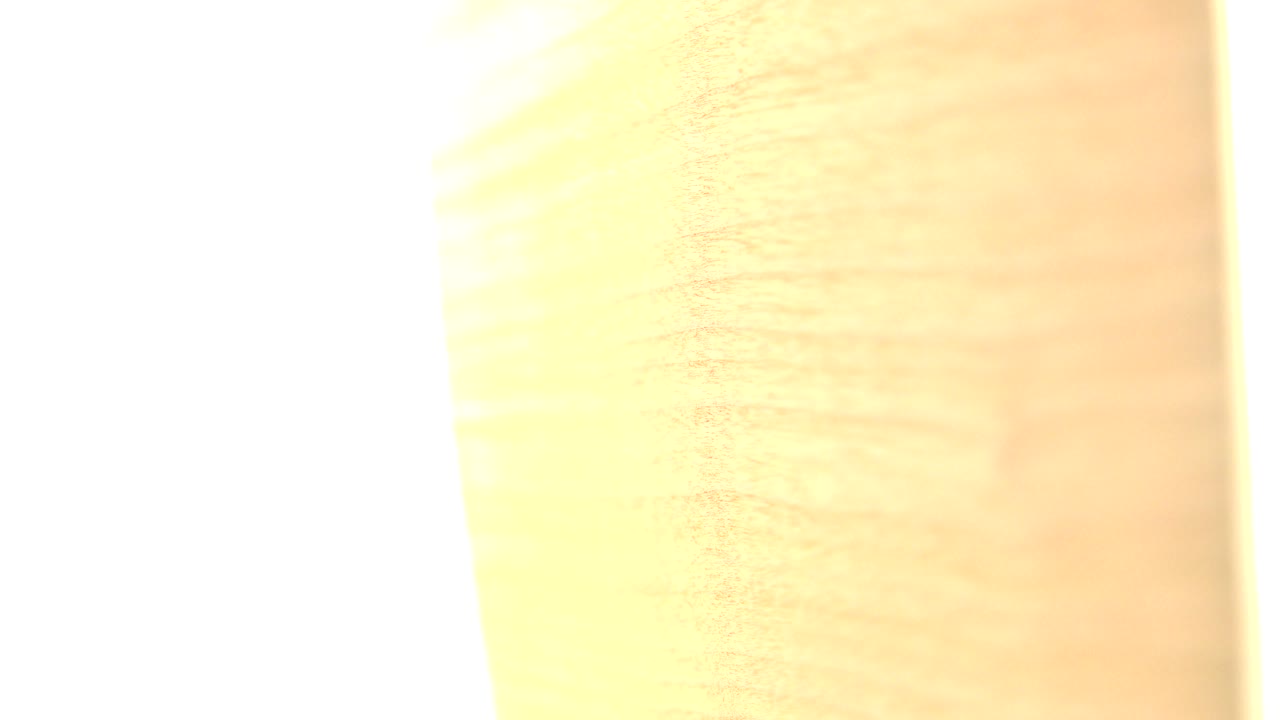 A close view of the tan wood sheet shows soft grain lines and a wide overexposed white strip at the left side, with no visible people.