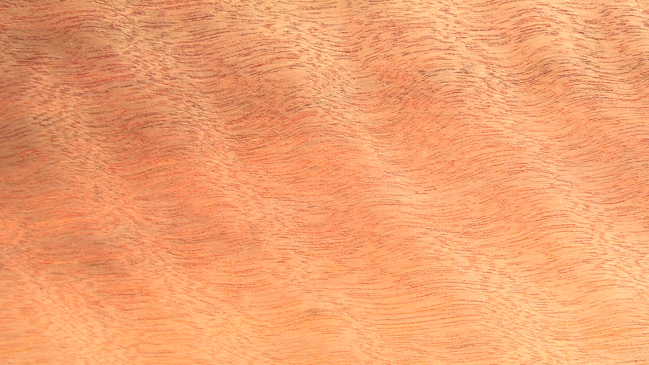 A warm wood board surface fills the second frame, with fine striations running across the image and no visible people.