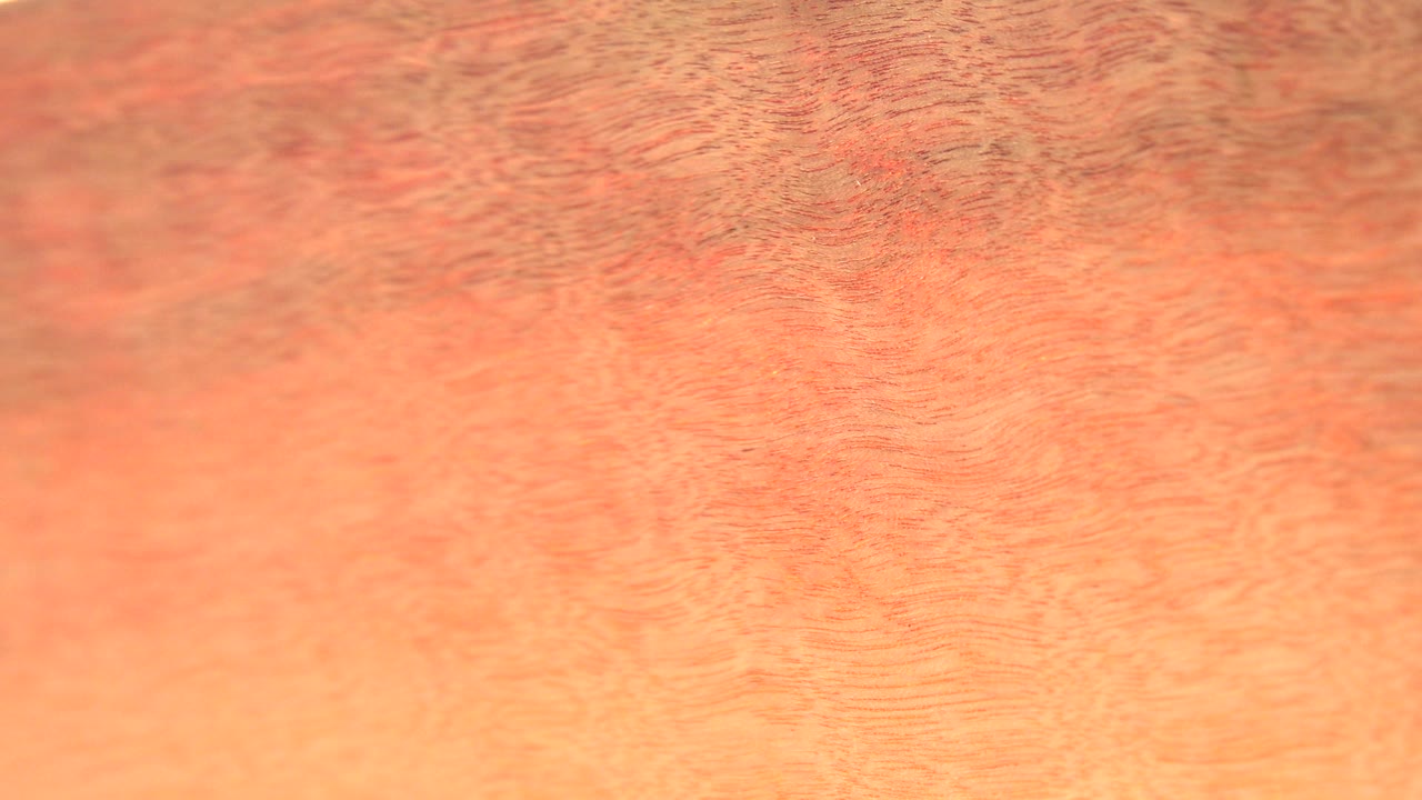 Soft tan wood surface with darker grain marks.