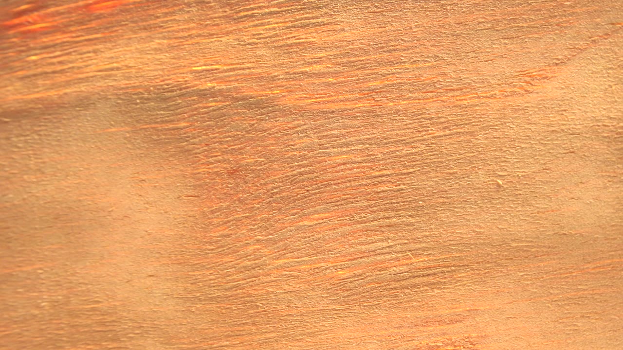 The rotating wood surface shifts to show a bright overexposed vertical edge on the right side in the Westminster, Colorado clip, with no visible people.