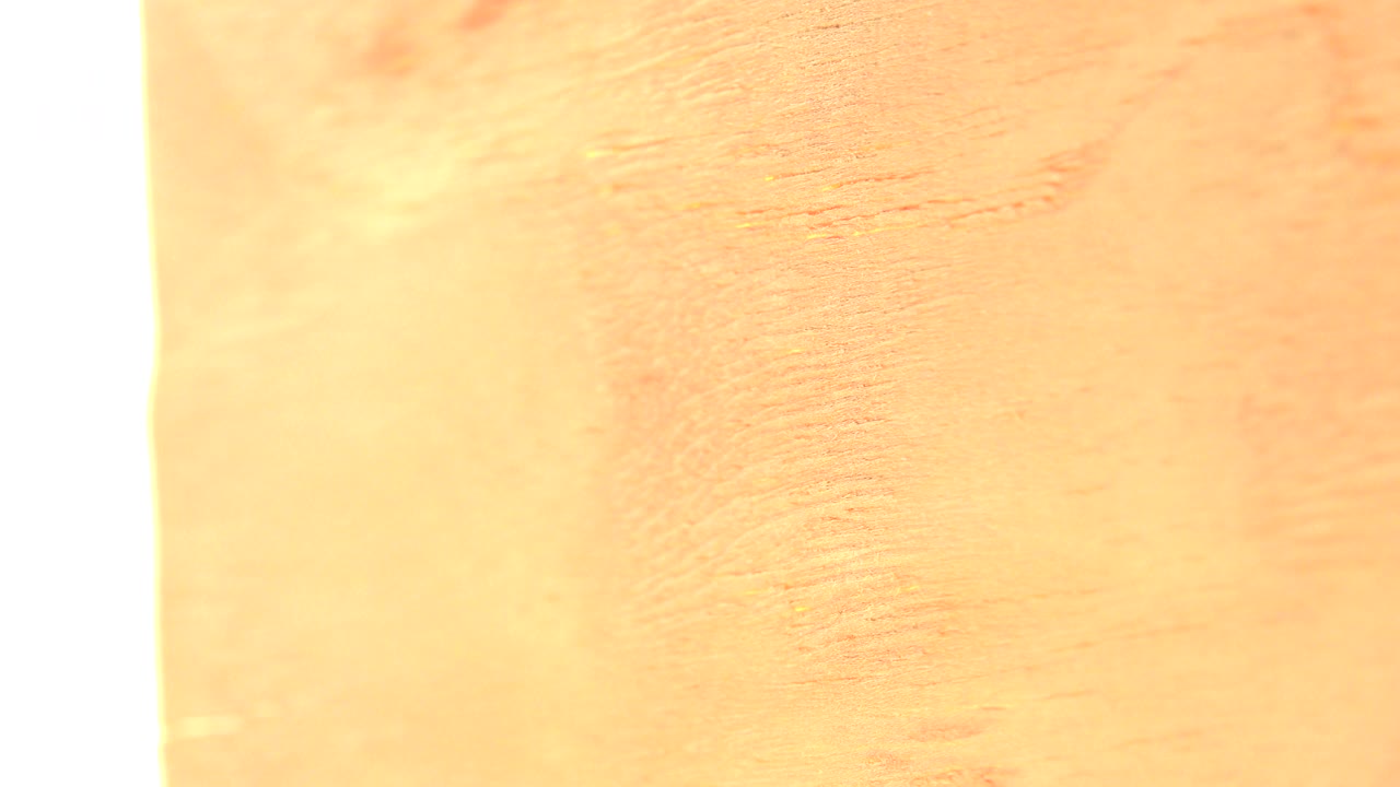 Overexposed white band beside a pale yellow wood surface.