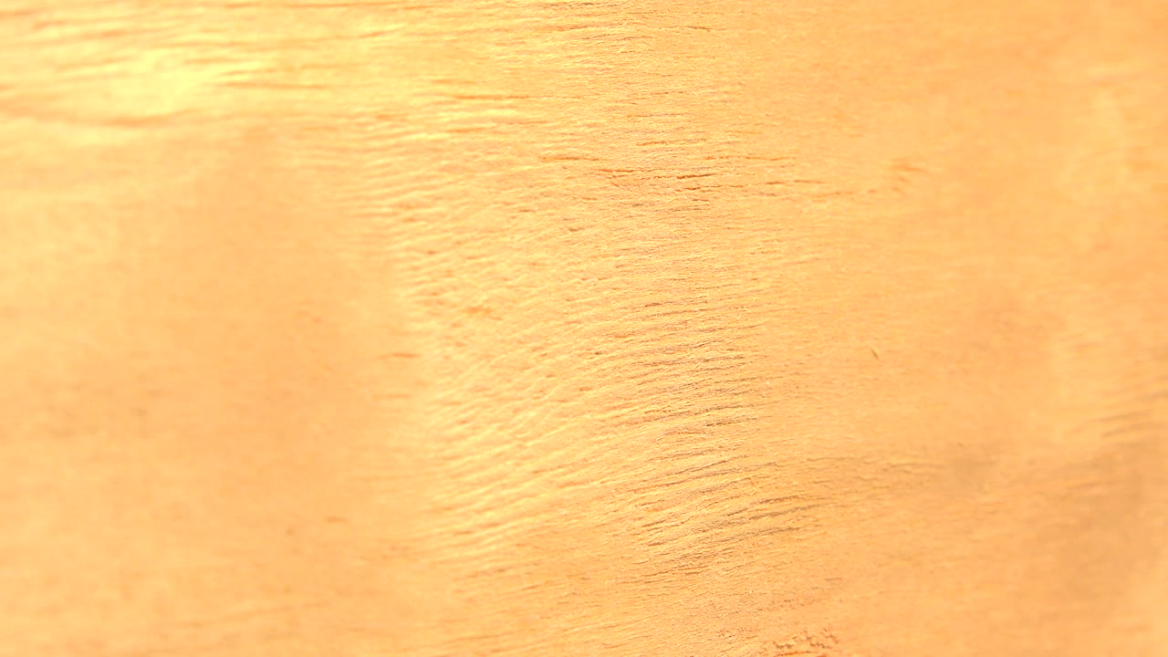 Orange surface texture with stronger grain near the top edge.