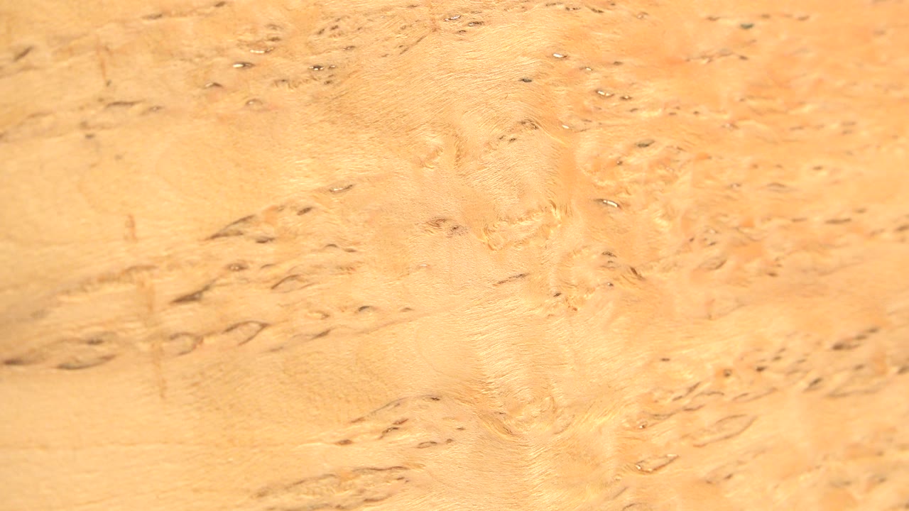 Close view of a yellow marked metal-like surface in Westminster, Colorado, with dark specks, shallow scratches, and no visible people.