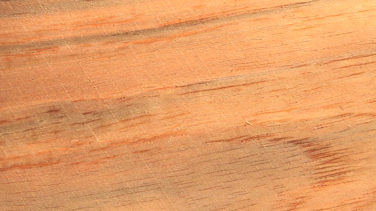 Close view of a warm orange textured sheet with dark streaks.