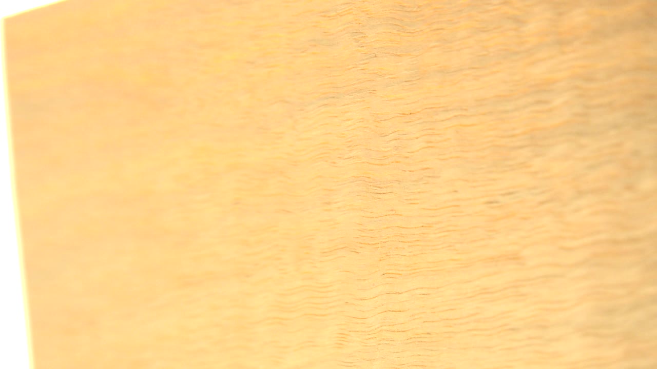 A close-up section of yellow plywood in Westminster, Colorado, showing a narrow white overexposed strip on the left and no visible people.