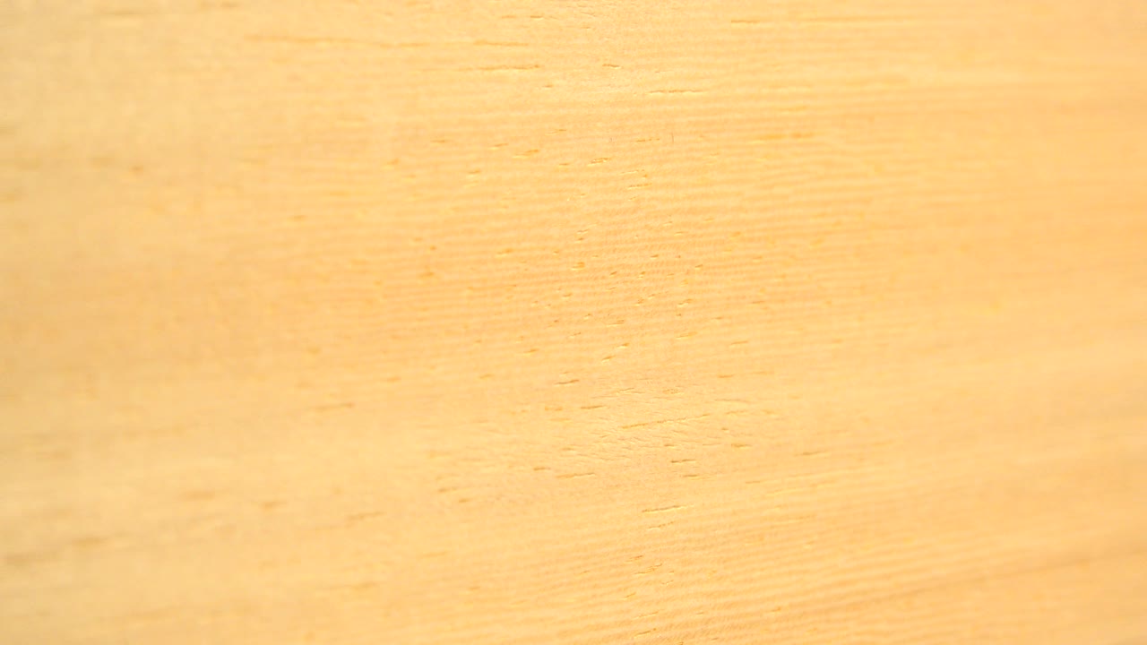 A brighter close-up section of the yellowish surface in the Westminster, Colorado footage, showing soft grain, slight tonal variation, and no visible people.