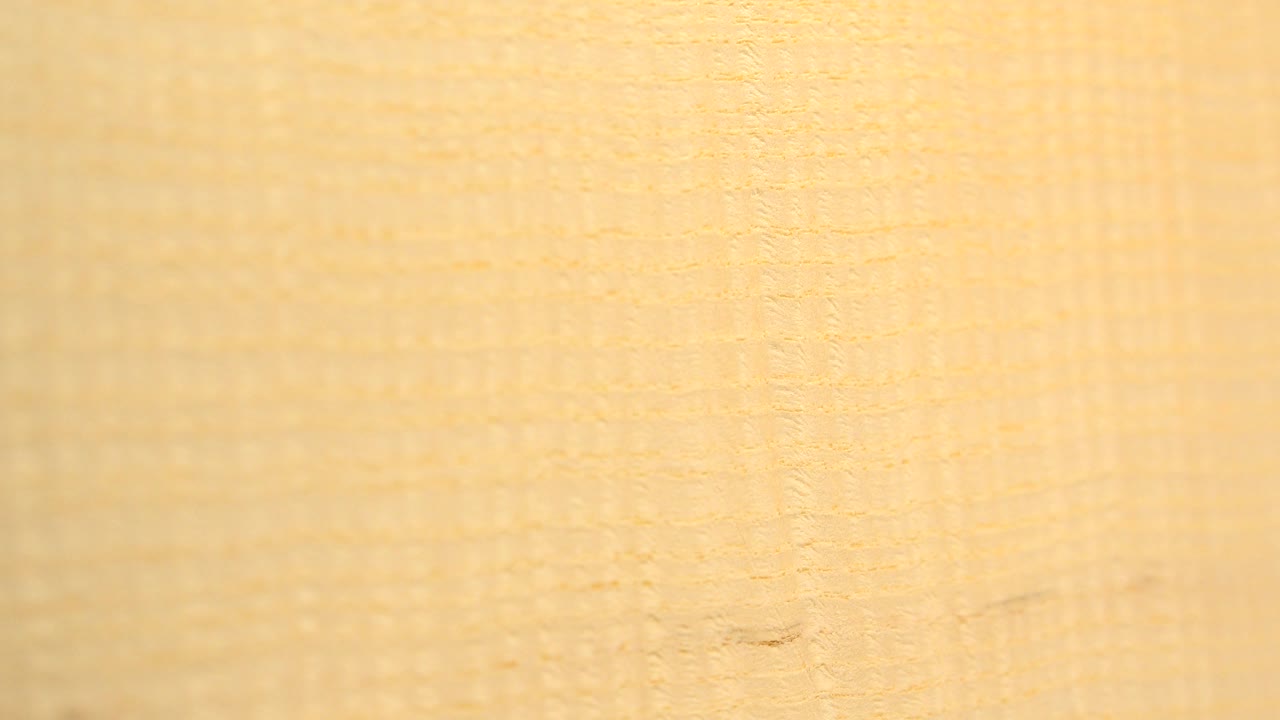 A closer-looking section of tan wood grain shows denser vertical and crosshatched texture in the Westminster, Colorado footage, with no visible people.