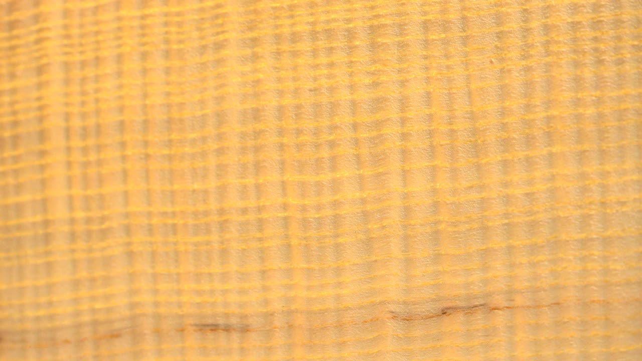 Close view of the yellow object in Westminster, Colorado, showing woven or wood-grain-like lines across the surface and no visible people.