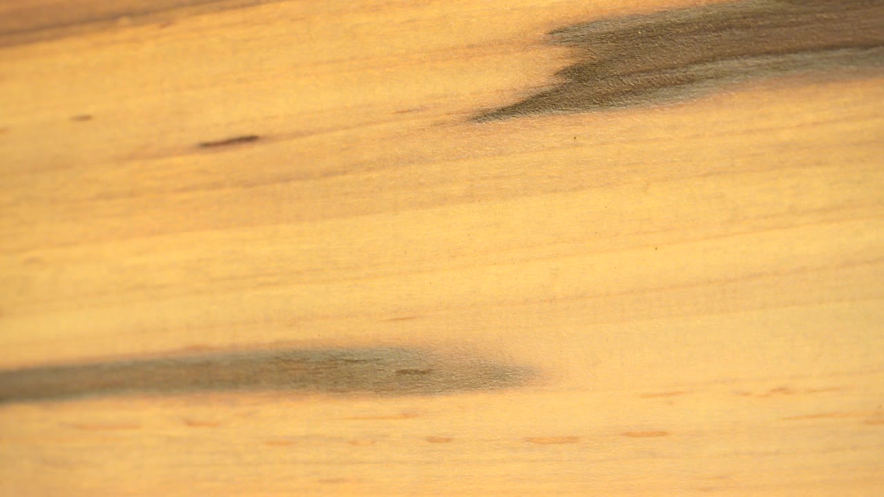 A tight Westminster, Colorado close-up shows pale wood grain with dark horizontal streaks near the top and lower left, with no visible people.