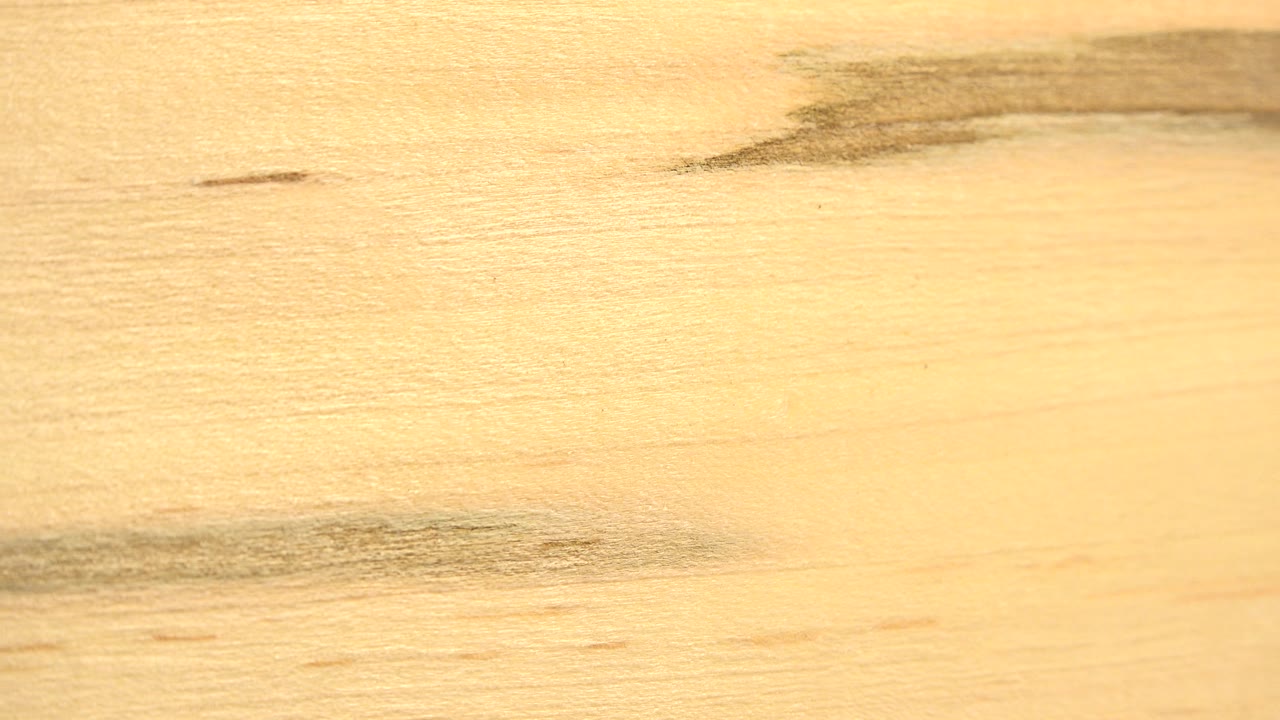 Wood surface filled with tan color and two dark horizontal grain streaks.