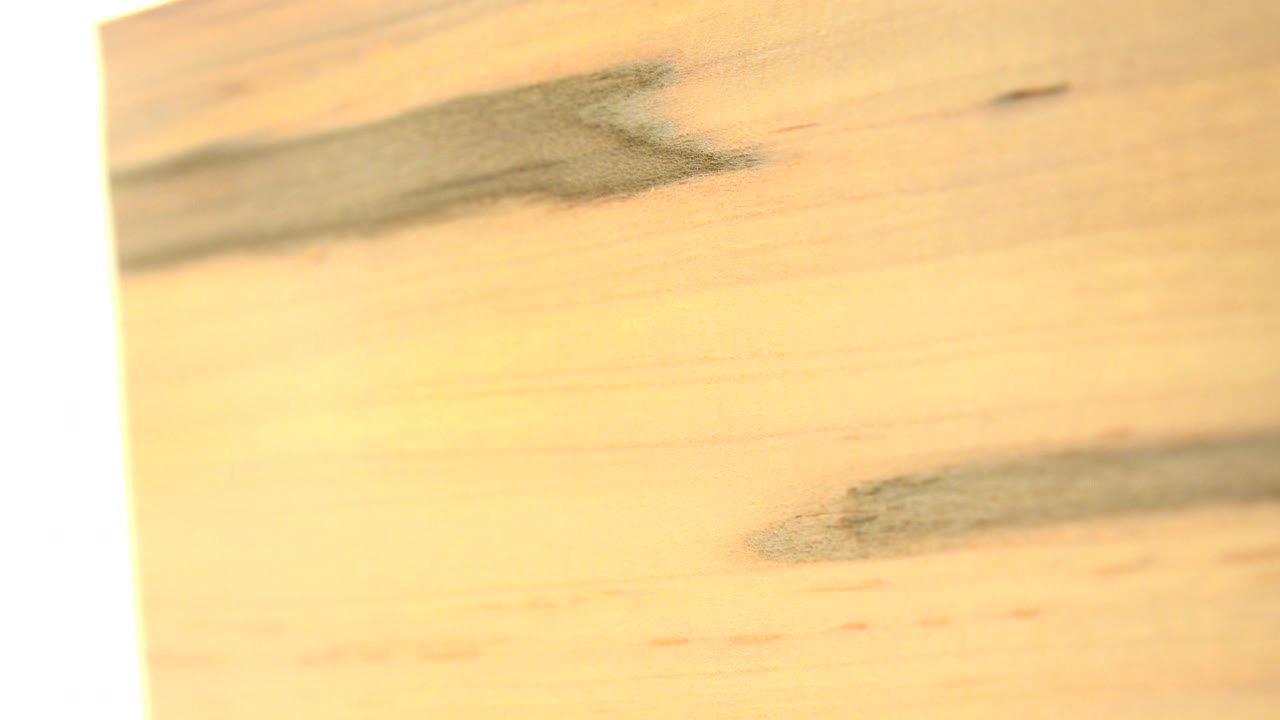 Tilted pale wooden surface beside a bright vertical edge.