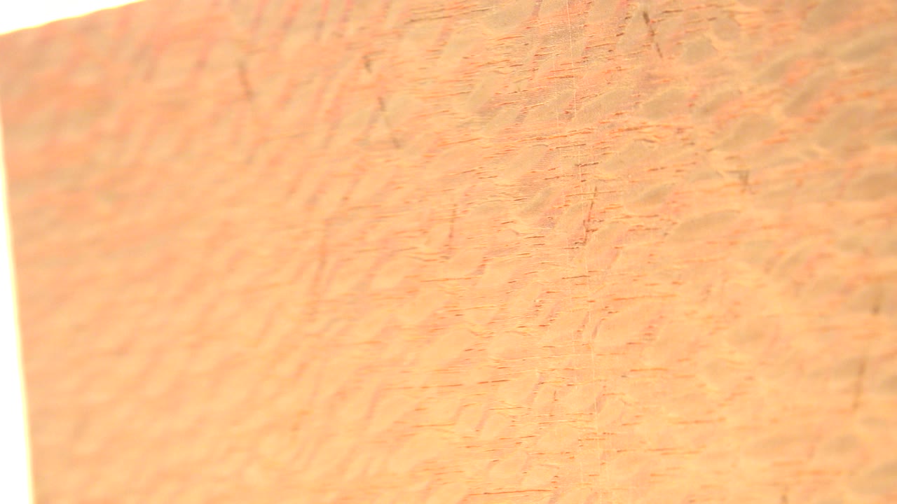 Close-up gold-colored textured surface with bright warm light.