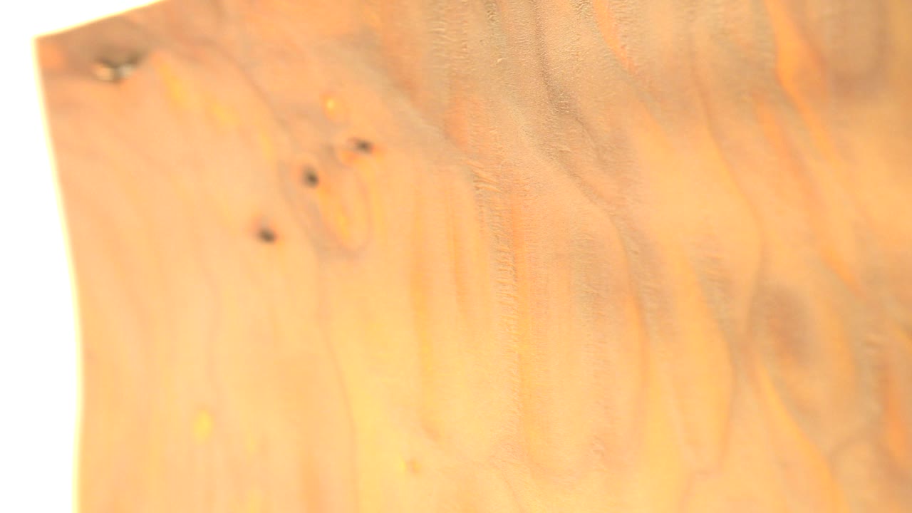 The second Westminster, Colorado frame keeps the coin close to camera, with the gold surface shifted slightly and a bright white light strip along the left edge, with no visible people.