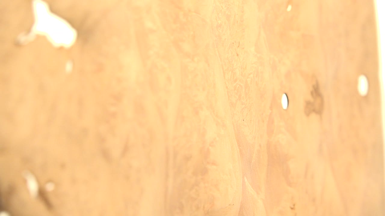 At 0:00, a soft orange computer-generated surface fills the frame in Westminster, Colorado footage, with pale highlights, faint dark marks, and no visible people.
